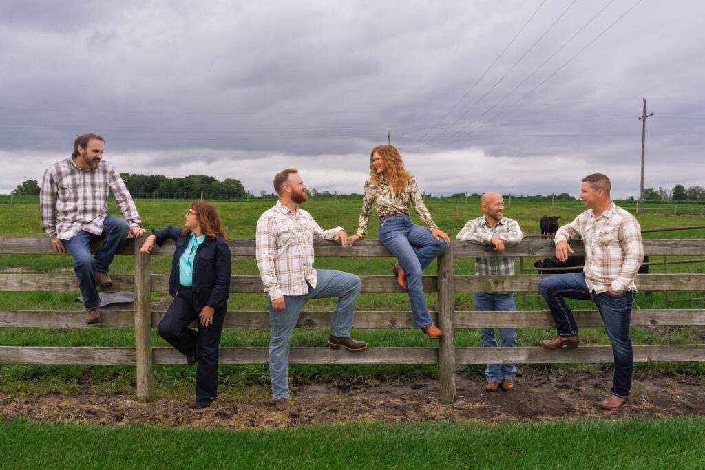 The Hageman Realty team along a wooden pasture fence