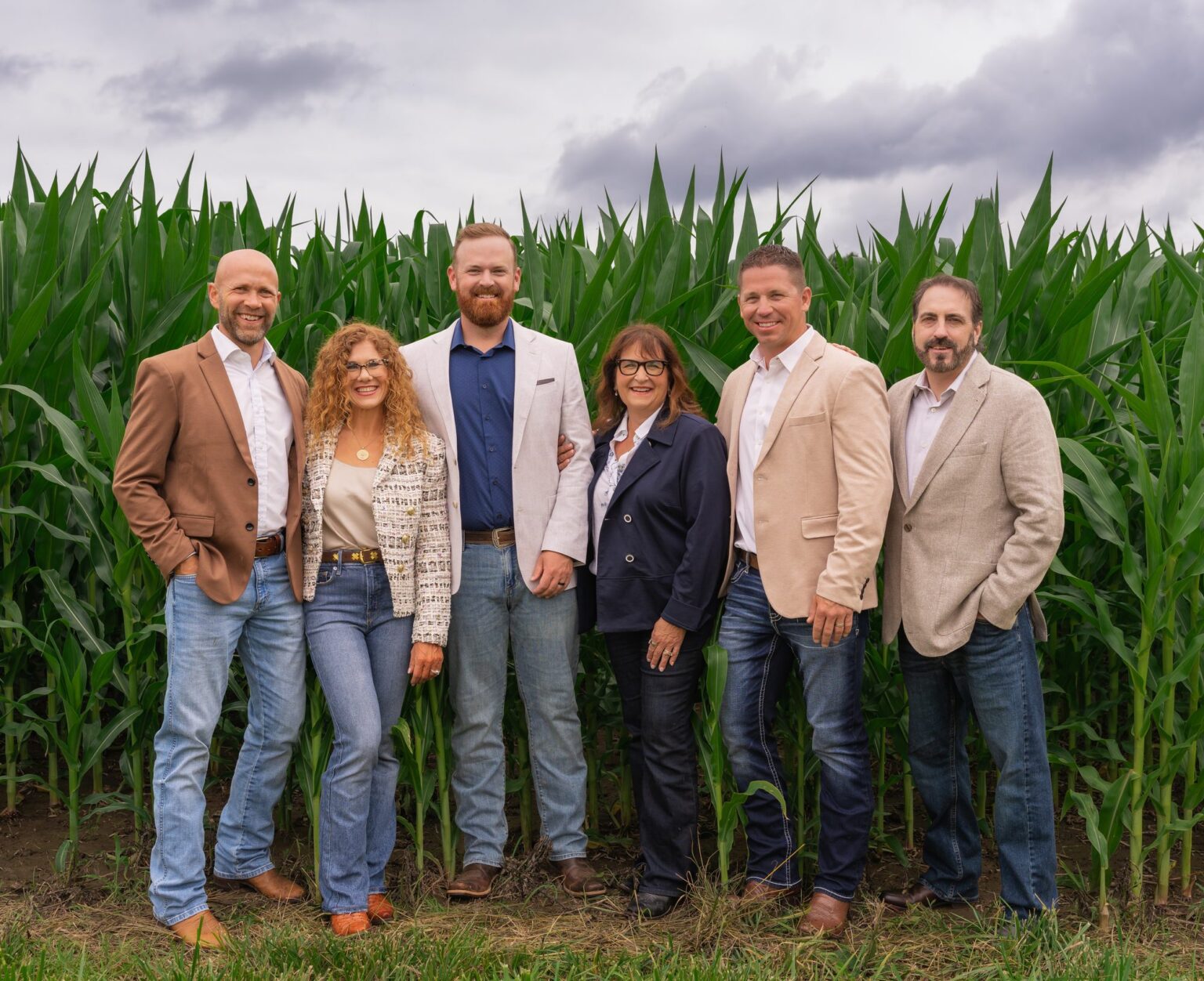 Hageman Realty's six brokers standing in front of a cornfield, 2026