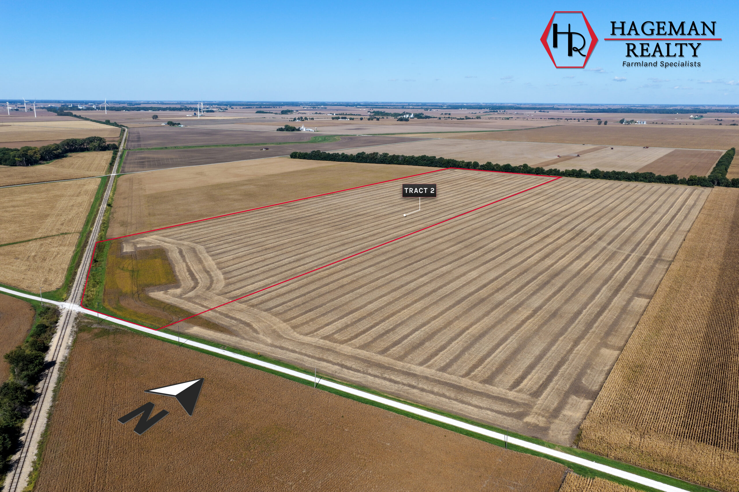 Portteus Farm Tract 2 along a county road and rail line, harvested cropland with wind turbines on the horizon